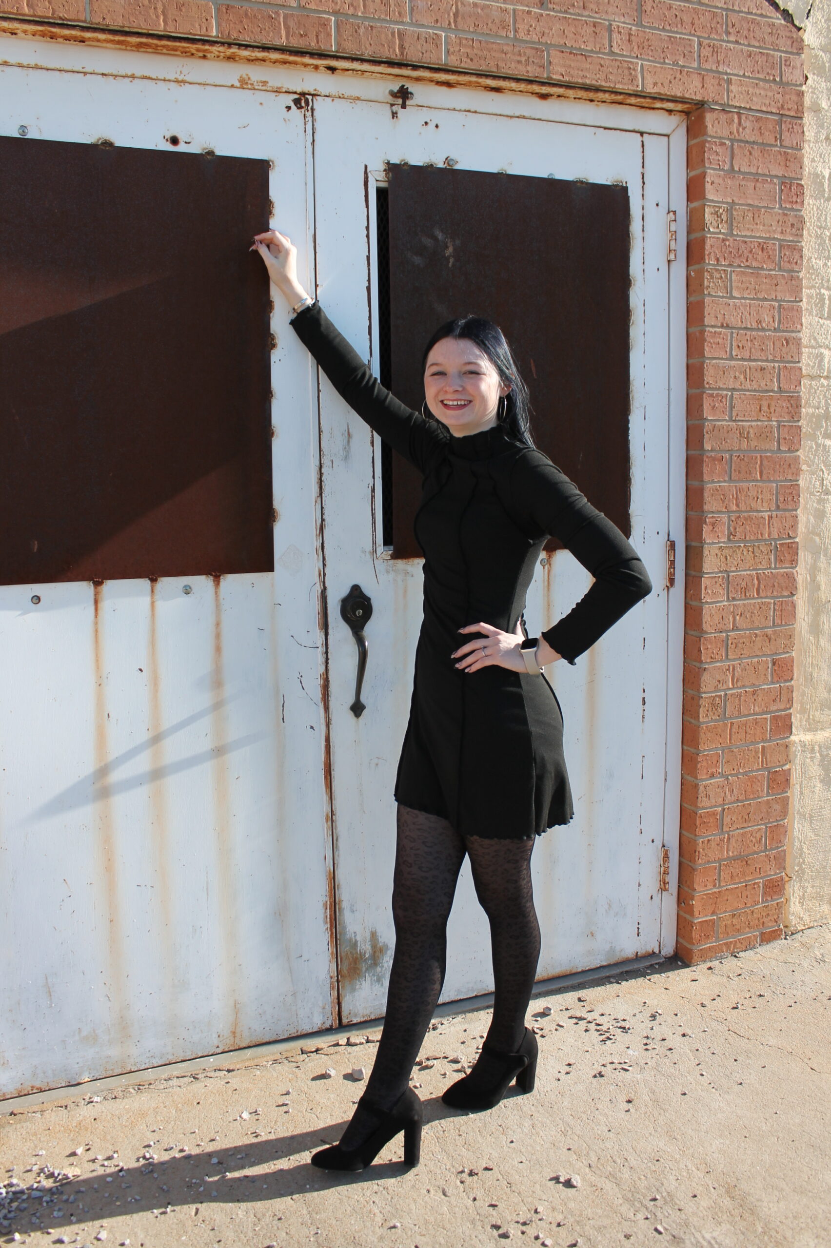 This is an image of Carly Nickole leaning against a brick building.