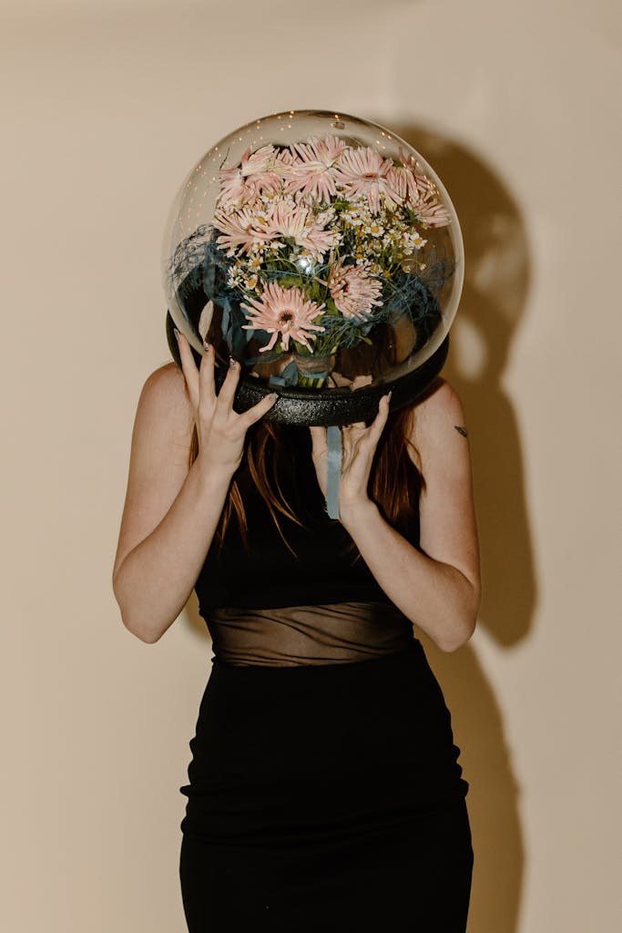 Woman who enjoys selfcare smiling through flower filled globe.