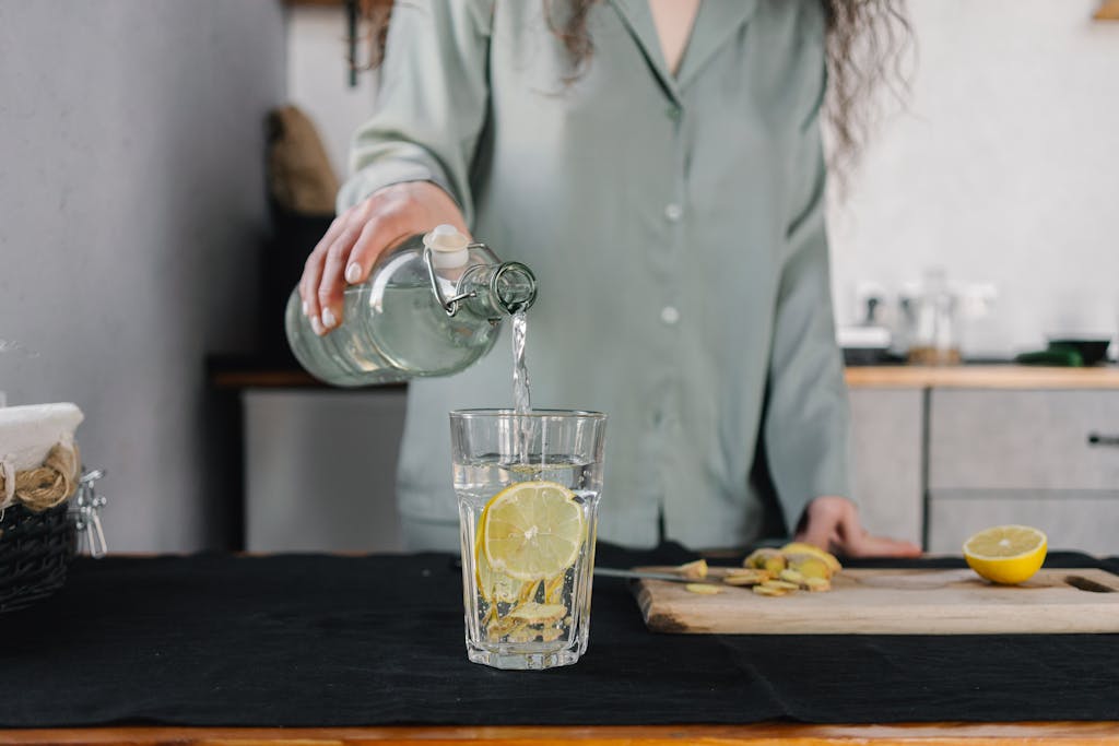 Woman drinking water with lemon during her stress free morning routine.